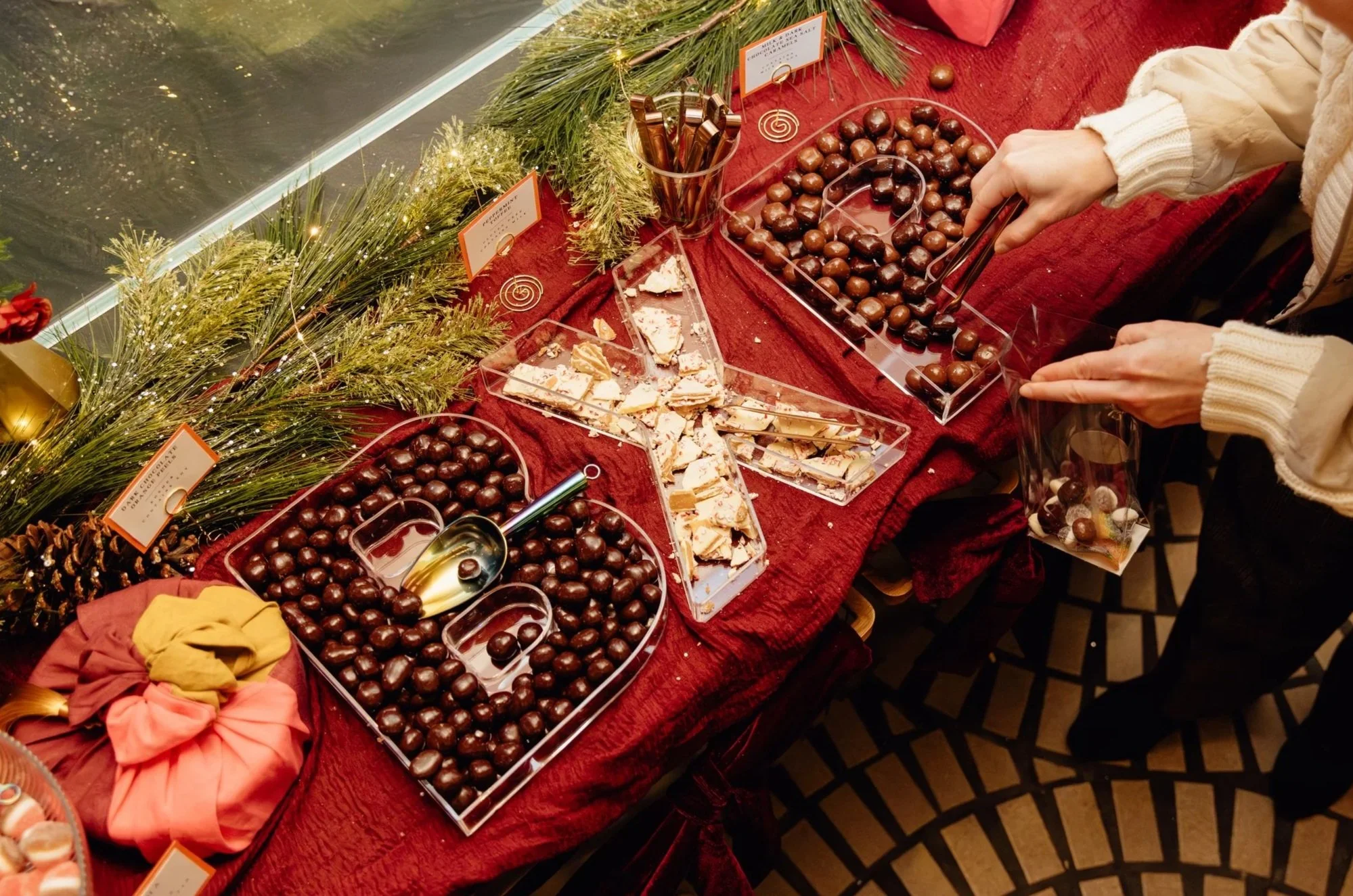 Clear glass vases filled with colorful gumballs and candies on a white counter.