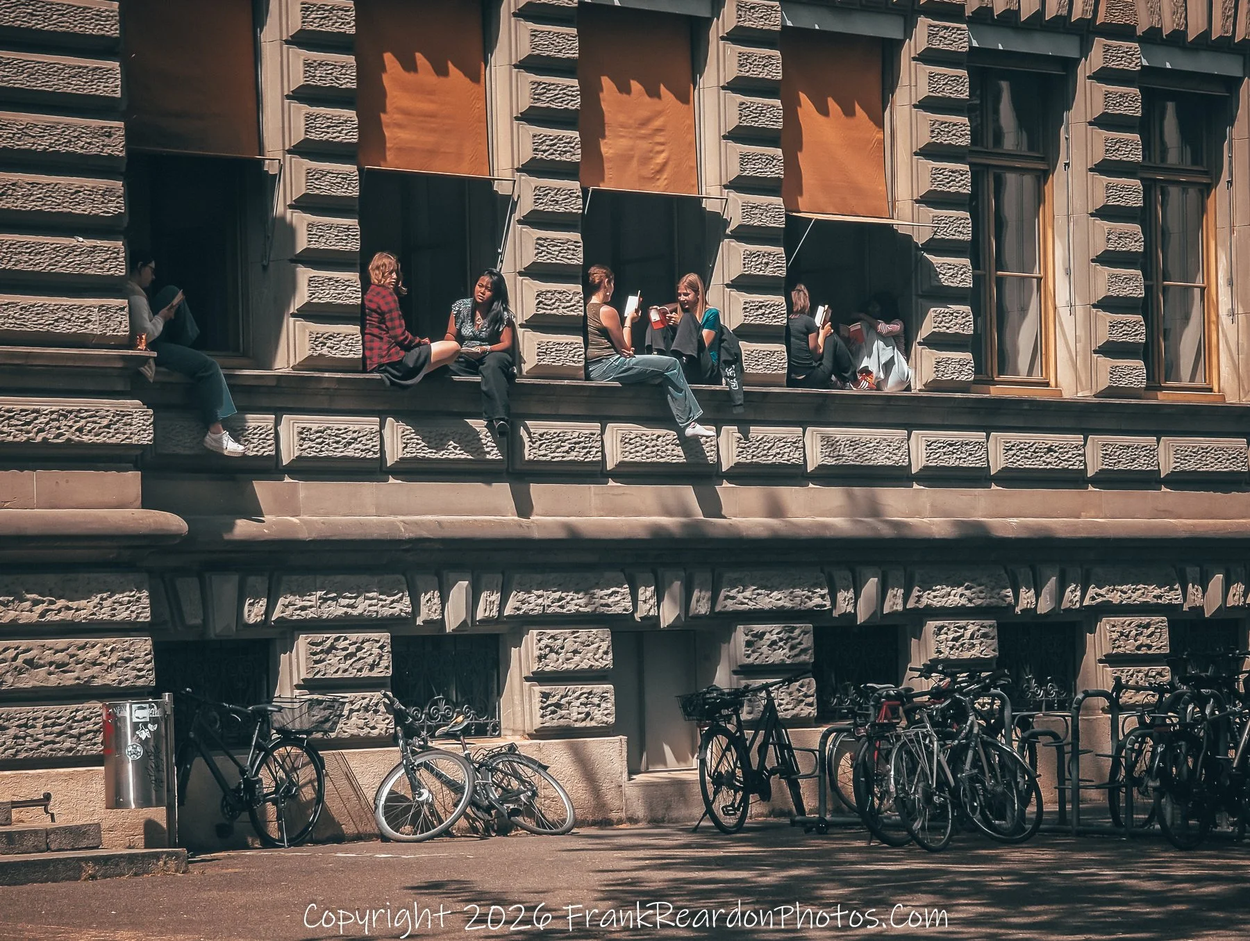 “Windows of Conversation” Students perched on ledges turn the façade into a stage for dialogue and sunlight.