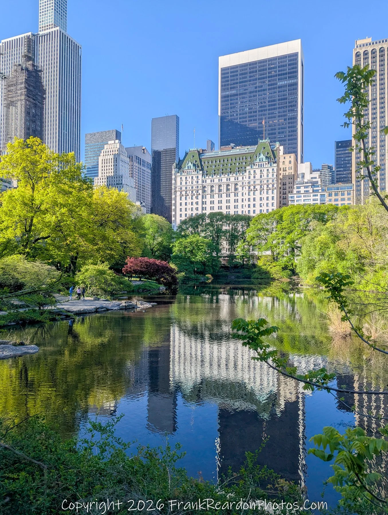 “The Plaza Reflected: Skyline on Still Water”