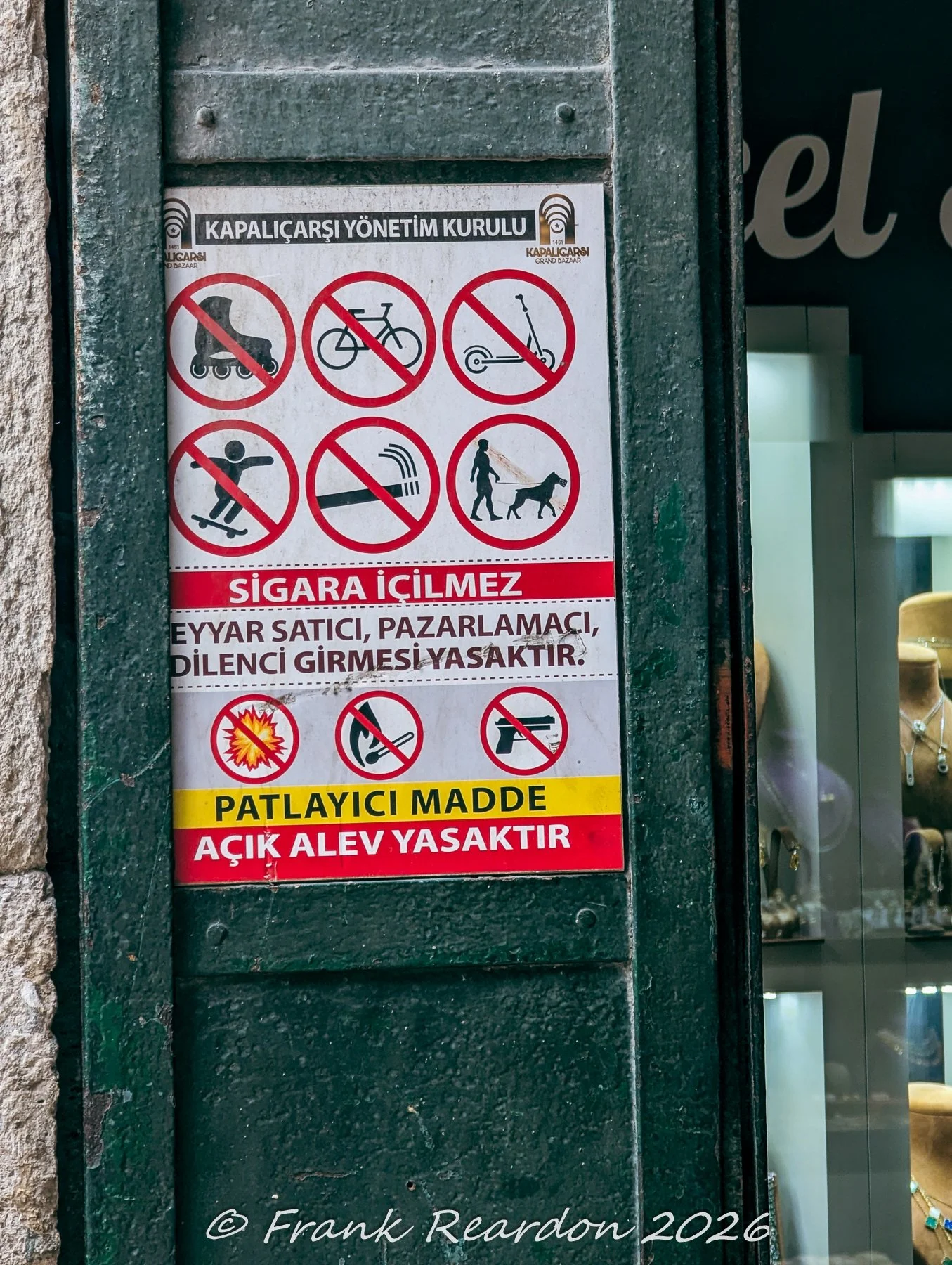 A bilingual notice posted on a doorway detailing prohibited items, safety regulations, and management rules set by the Grand Bazaar Directorate (Kapalıçarşı Yönetim Kurulu).