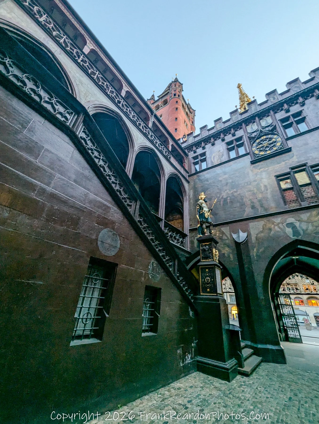 "Guardian of the Courtyard" A view featuring the decorative fountain and statue in the center of the Rathaus courtyard, with the building's intricate stone arches and painted walls in the background.