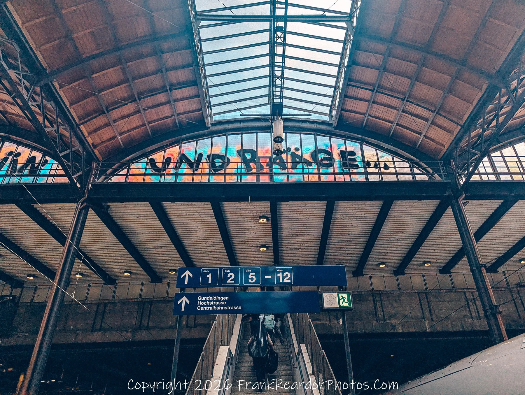 “Under Peace” The colorful mural above the platforms becomes a message of calm amid the flow of commuters.