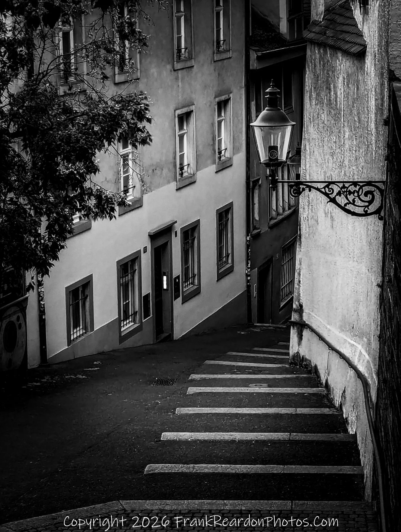 “Descent into Silence” A narrow lane and its solitary lamp evoke the quiet rhythm of Basel’s hidden quarters.