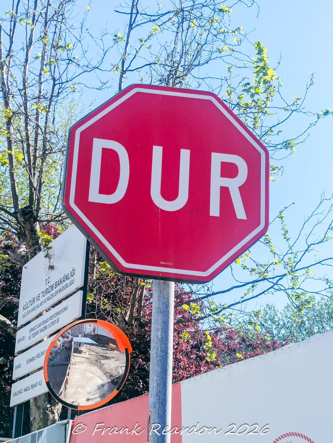 A red octagonal "DUR" (Stop) sign positioned in front of a construction and renovation notice from the Ministry of Culture and Tourism regarding the Sirkeci Train Station building restoration project (Sirkeci Gar Binası Restorasyonu).