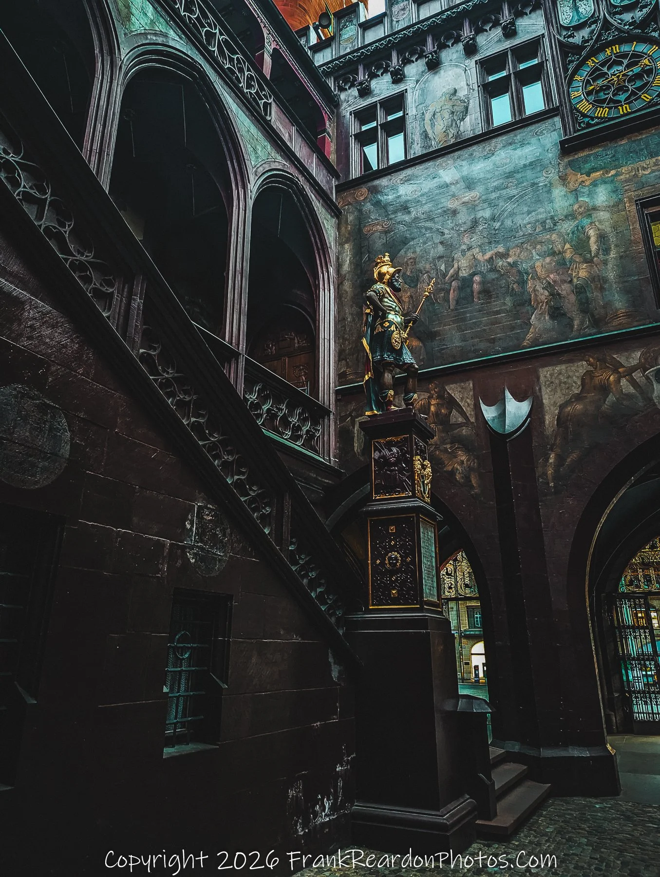 "Intricate Details of the Rathaus" A detailed look at the golden statue and vibrant mural artwork adorning the historic walls within the Rathaus courtyard.