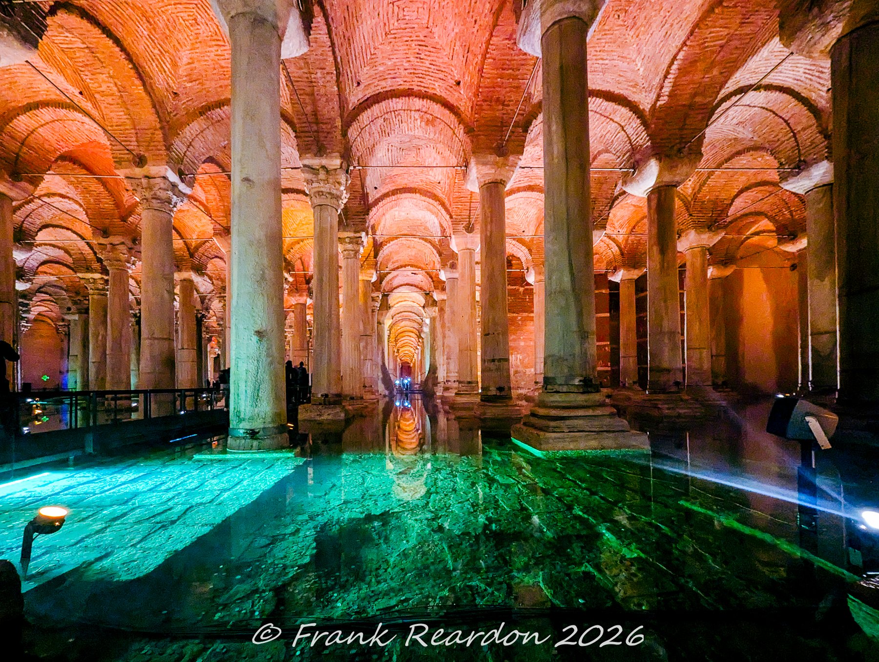 A view across the subterranean walkways highlighting the greenish underwater lighting and majestic rows of ancient Roman columns.