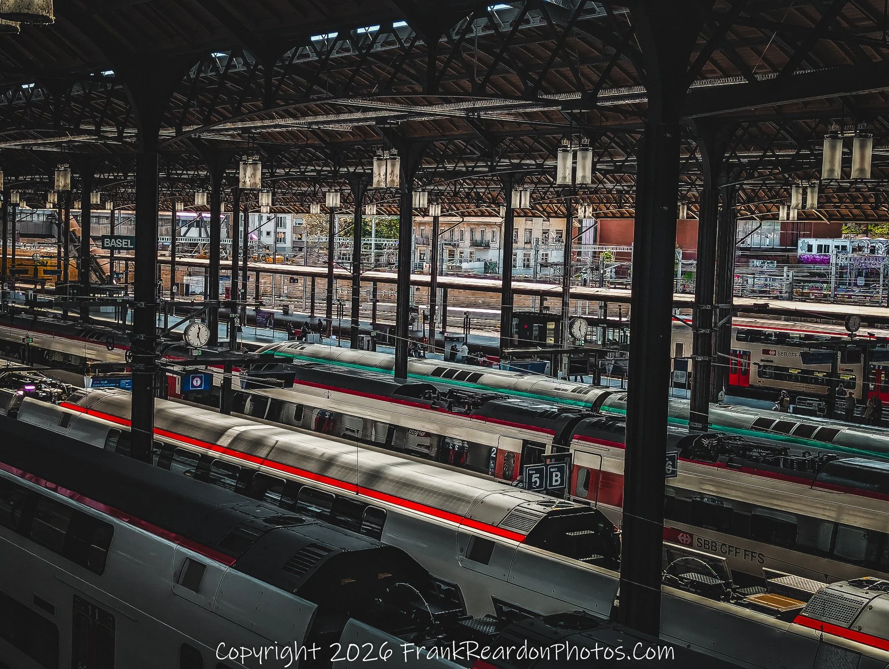 "Tracks at Rest" An elevated perspective looking out across the multiple train lines and platforms, showcasing the orderly arrangement of waiting SBB CFF FFS trains.