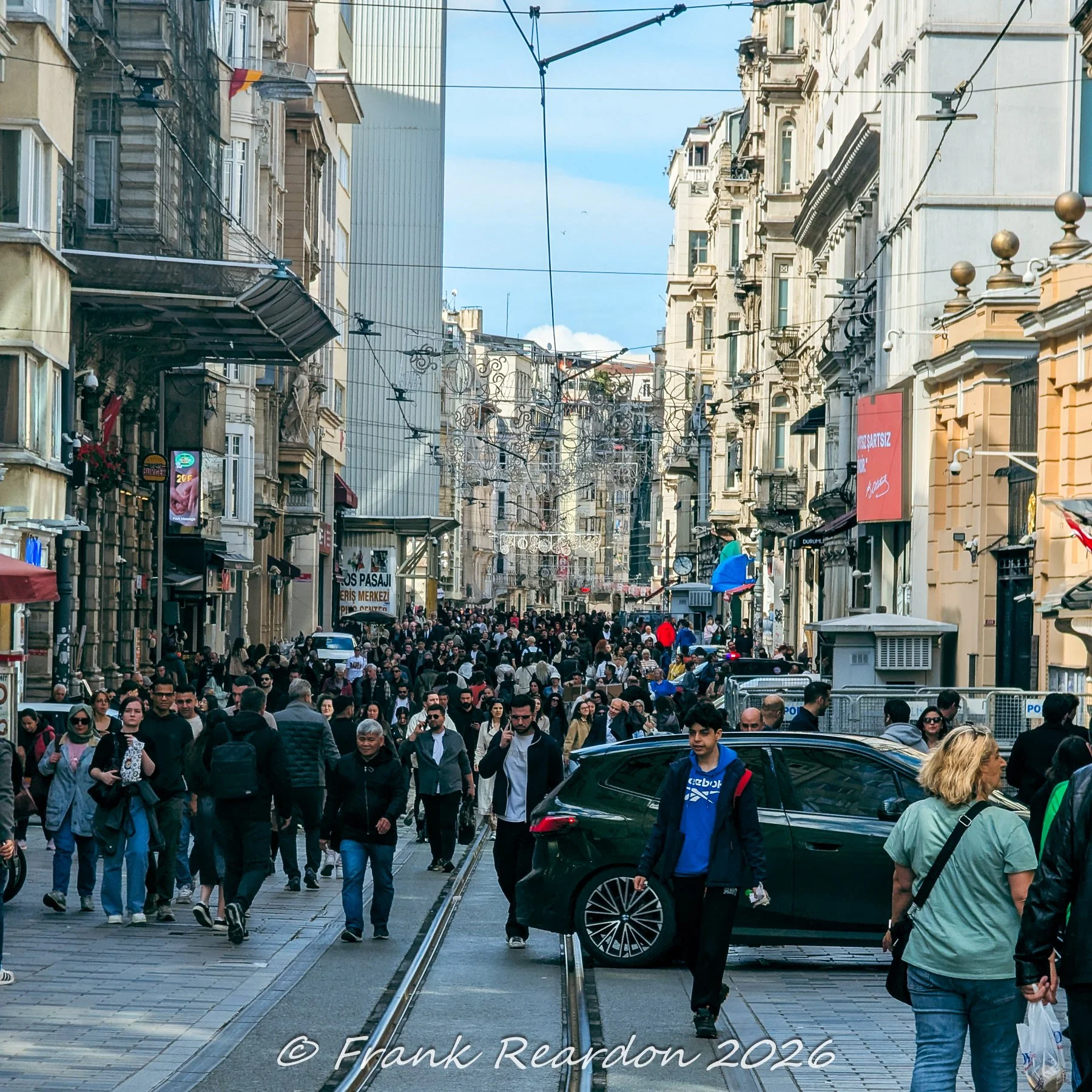 A dense crowd of pedestrians walking along the vibrant and lively pedestrian corridor of Istiklal Avenue.