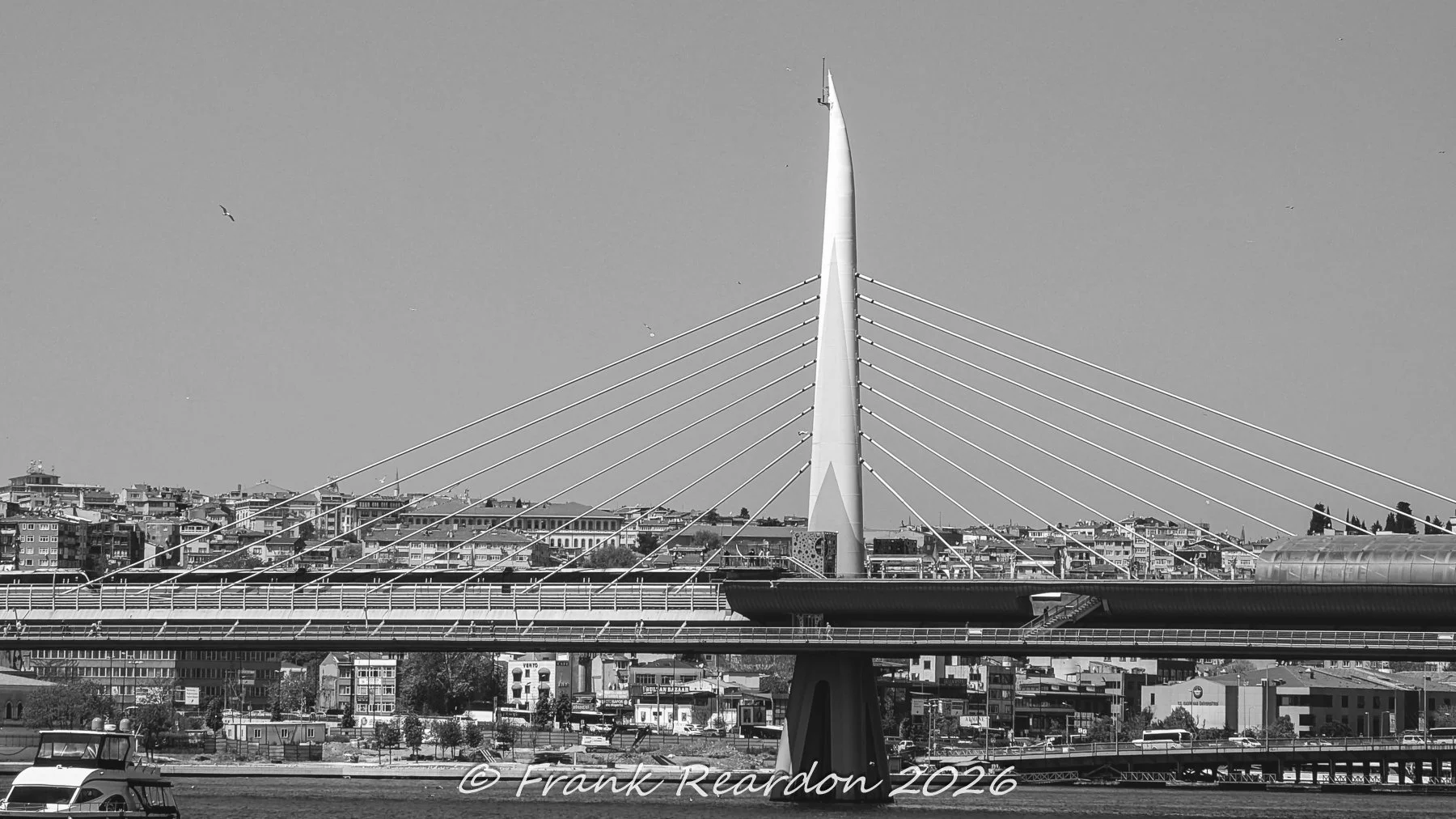 A high-contrast black-and-white close-up of the sleek, futuristic central pylon and stay cables of the Haliç Metro Bridge crossing the Golden Horn.