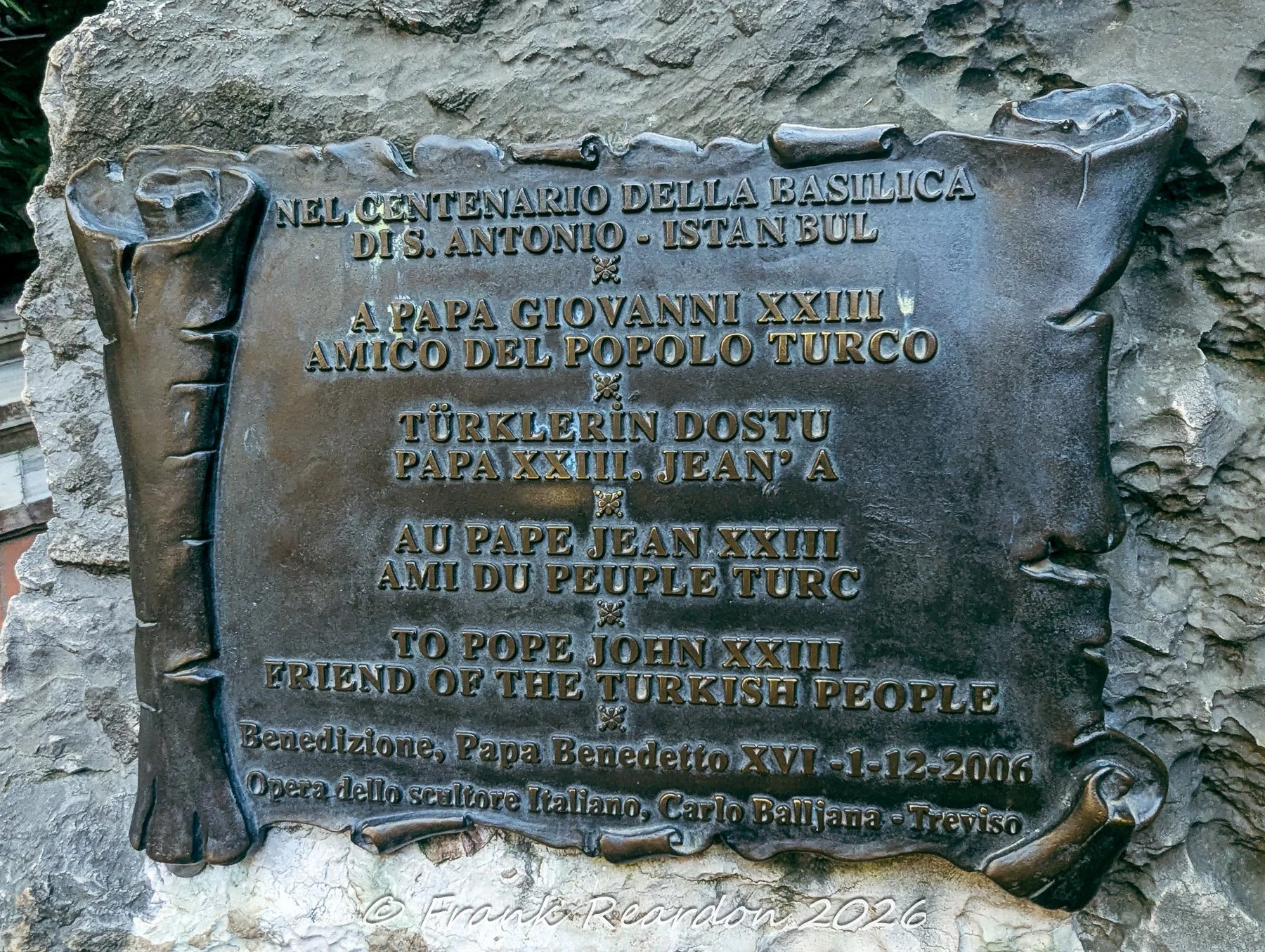 A commemorative bronze scroll plaque mounted on stone at the Church of Saint Anthony of Padua, honoring Pope John XXIII as a friend of the Turkish people.