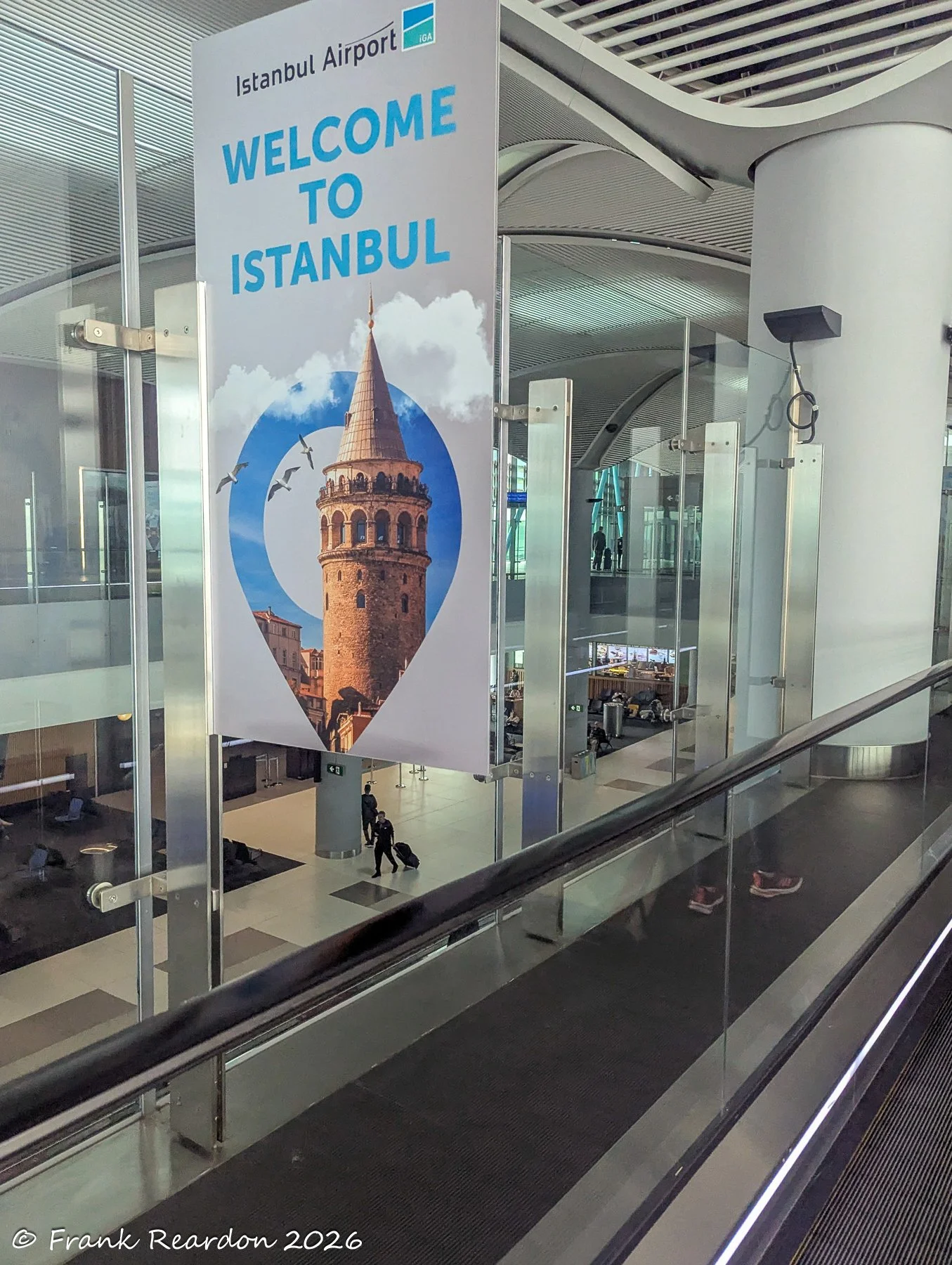 A striking "Welcome to Istanbul" hanging sign featuring an iconic image of the Galata Tower, welcoming travelers as they move through the terminal walkways.