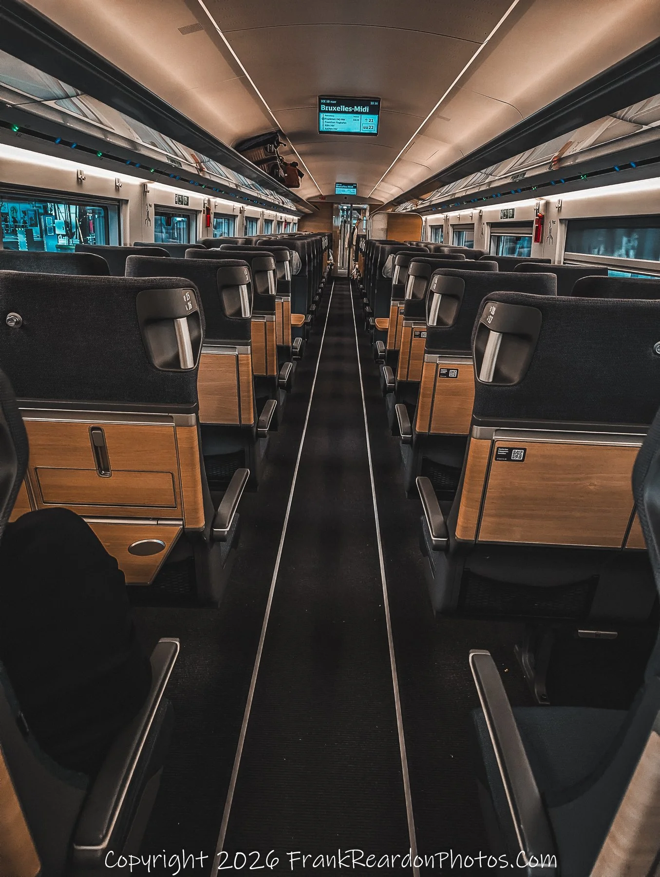 First Class Interior of an ICE Train.
A symmetrical, wide-angle shot looking down the central aisle of an empty first-class carriage