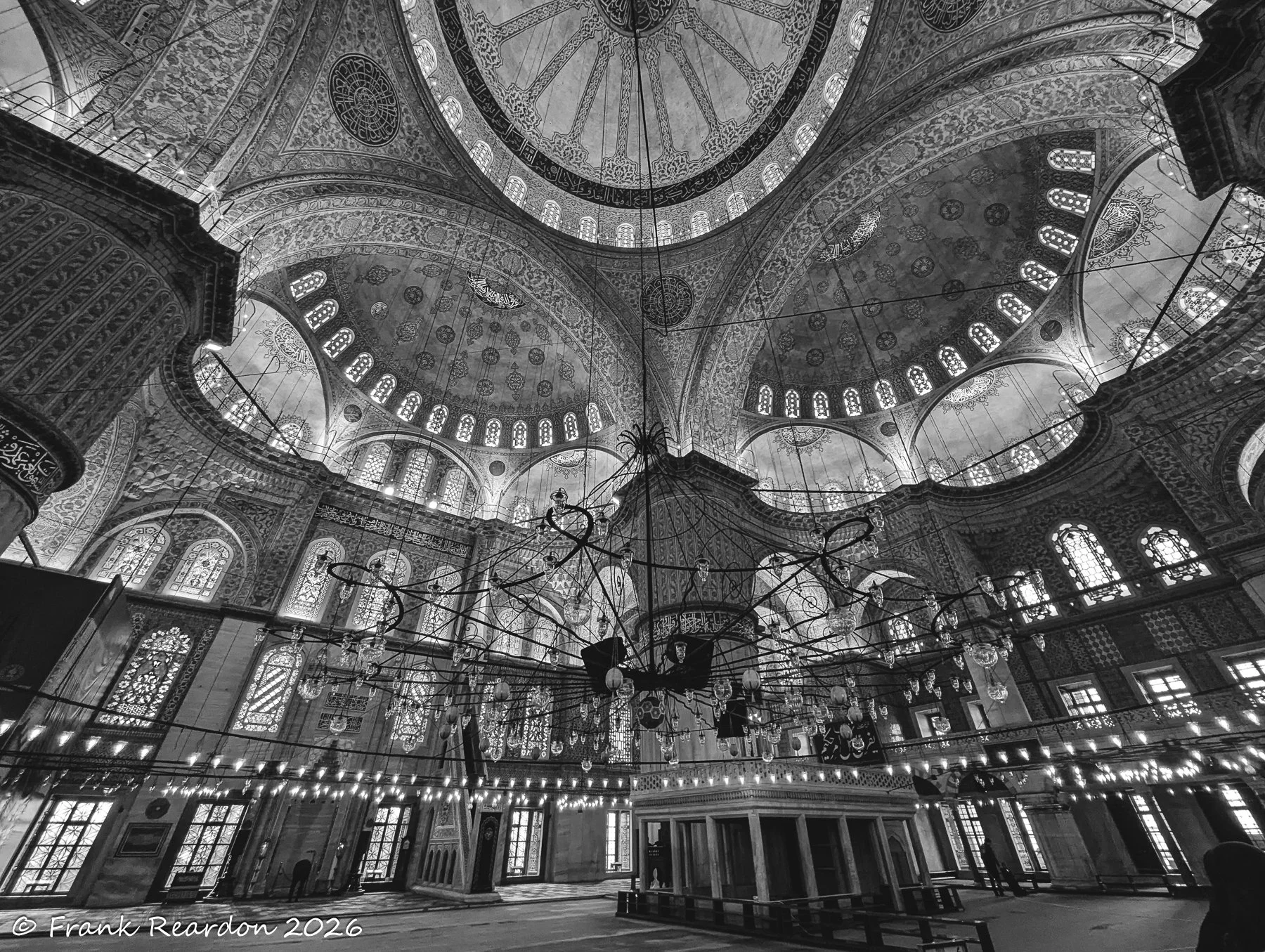 A striking monochrome perspective emphasizing the grand scale, structural ribs, and detailed ornamentation of the mosque's upper halls.