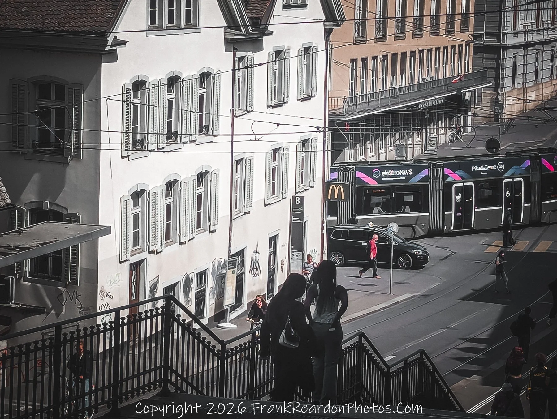 “Conversations on the Steps” A quiet exchange above the tram lines, where light and geometry meet human connection.