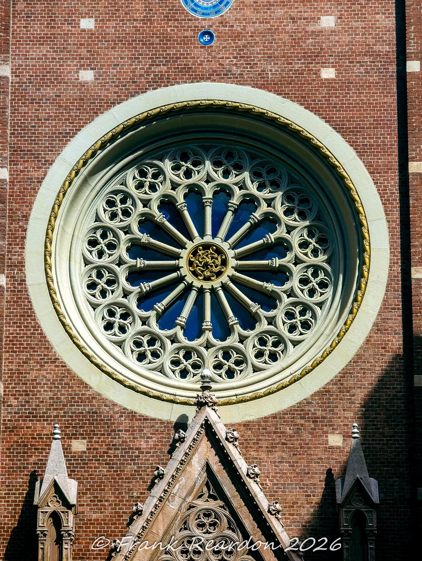 A detailed shot of the stunning Gothic Revival rose window on the brick facade of the Church of Saint Anthony of Padua on Istiklal Avenue.