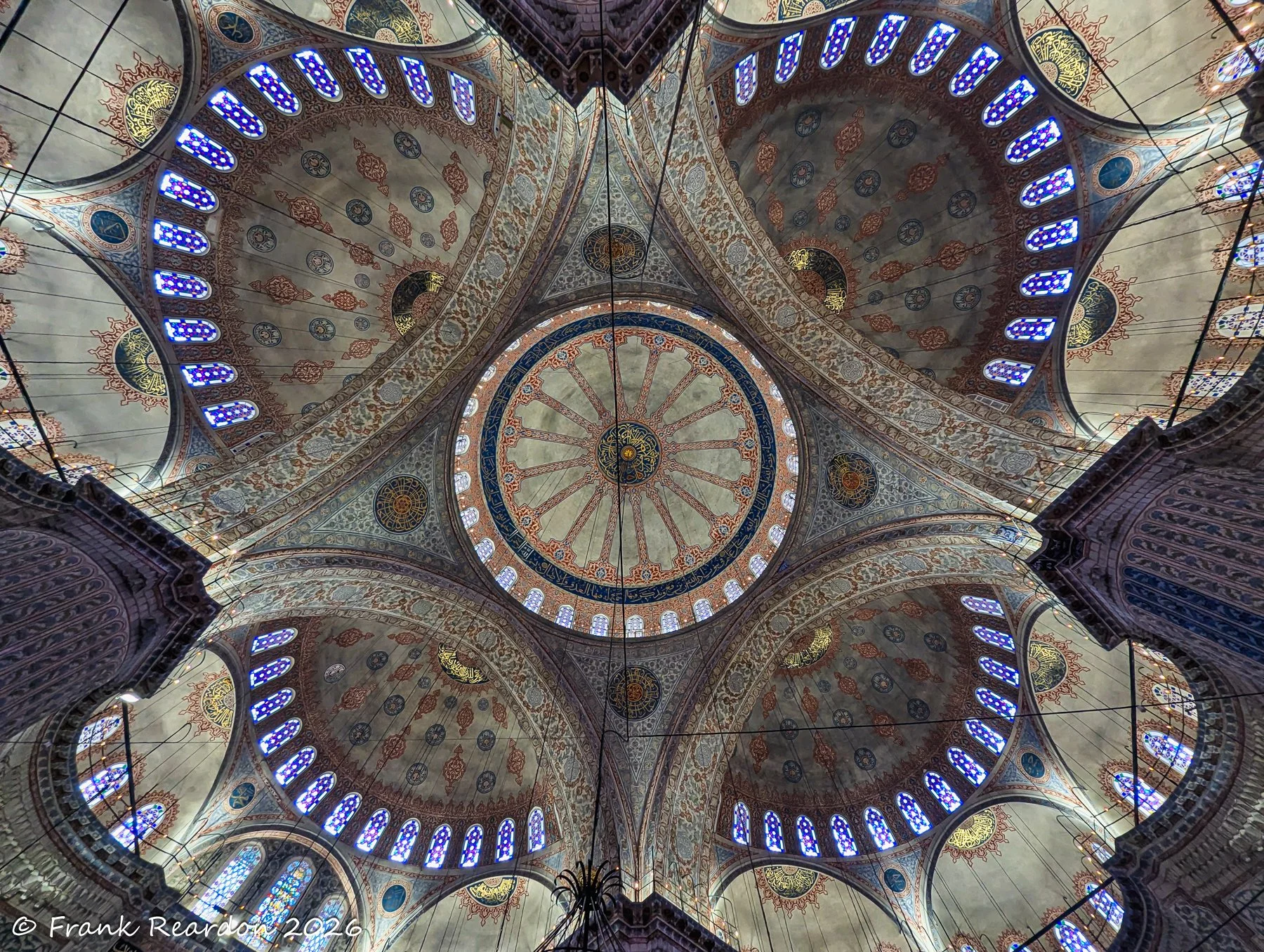 A vibrant, symmetrical upward shot of the central dome's elaborate circular patterns and surrounding stained glass.