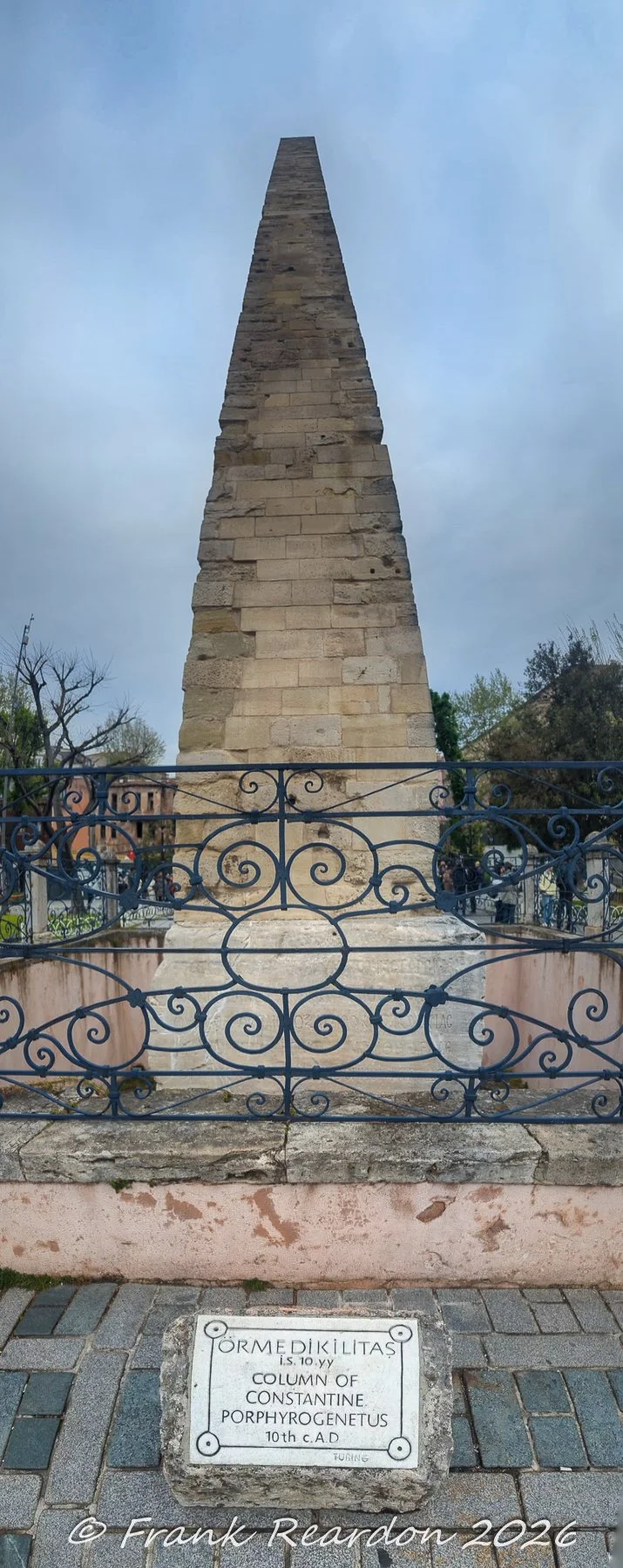 A close-up view showing the stone block construction and the descriptive plaque at the base of the Walled Obelisk in Sultanahmet Square.