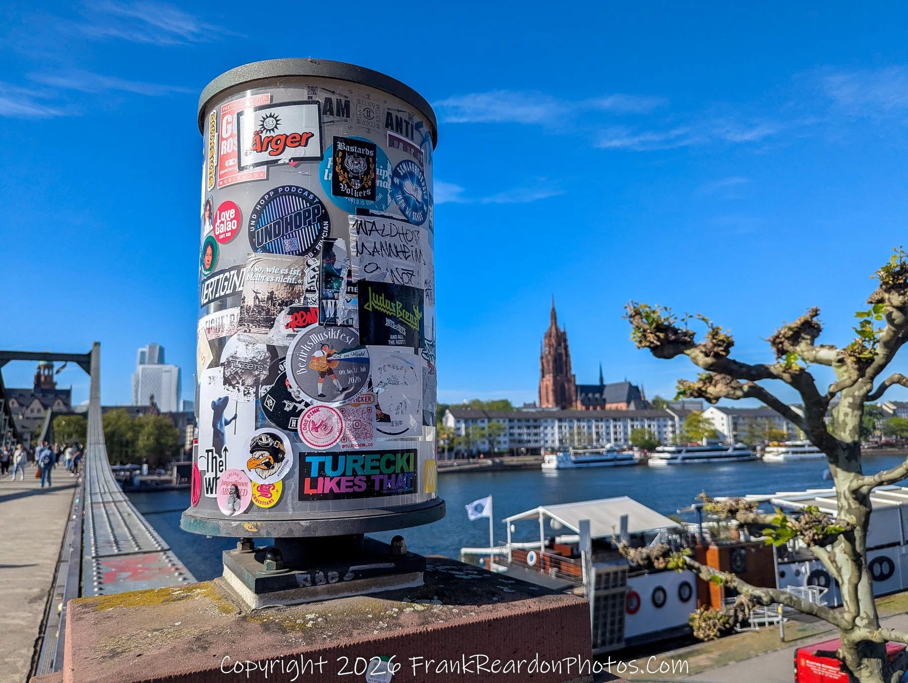 Sticker-Covered Post with Cathedral and River View
“Layers of the City – Stickers and Skyline”