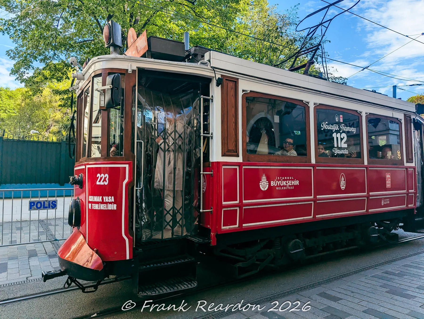A close-up profile view of the classic red and white nostalgic tram operating along the tracks.