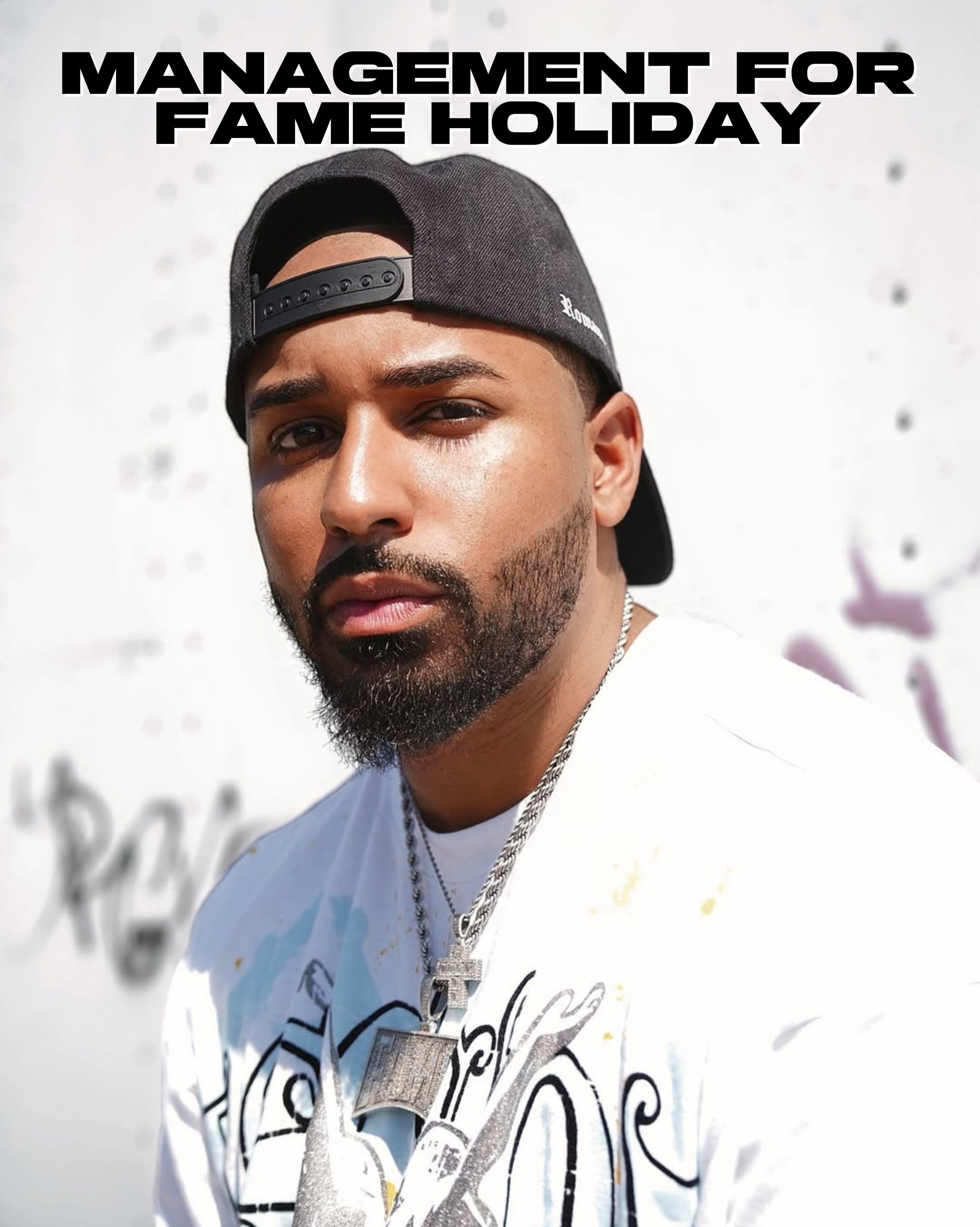 Fame Holiday with a black backwards snap back hat on.