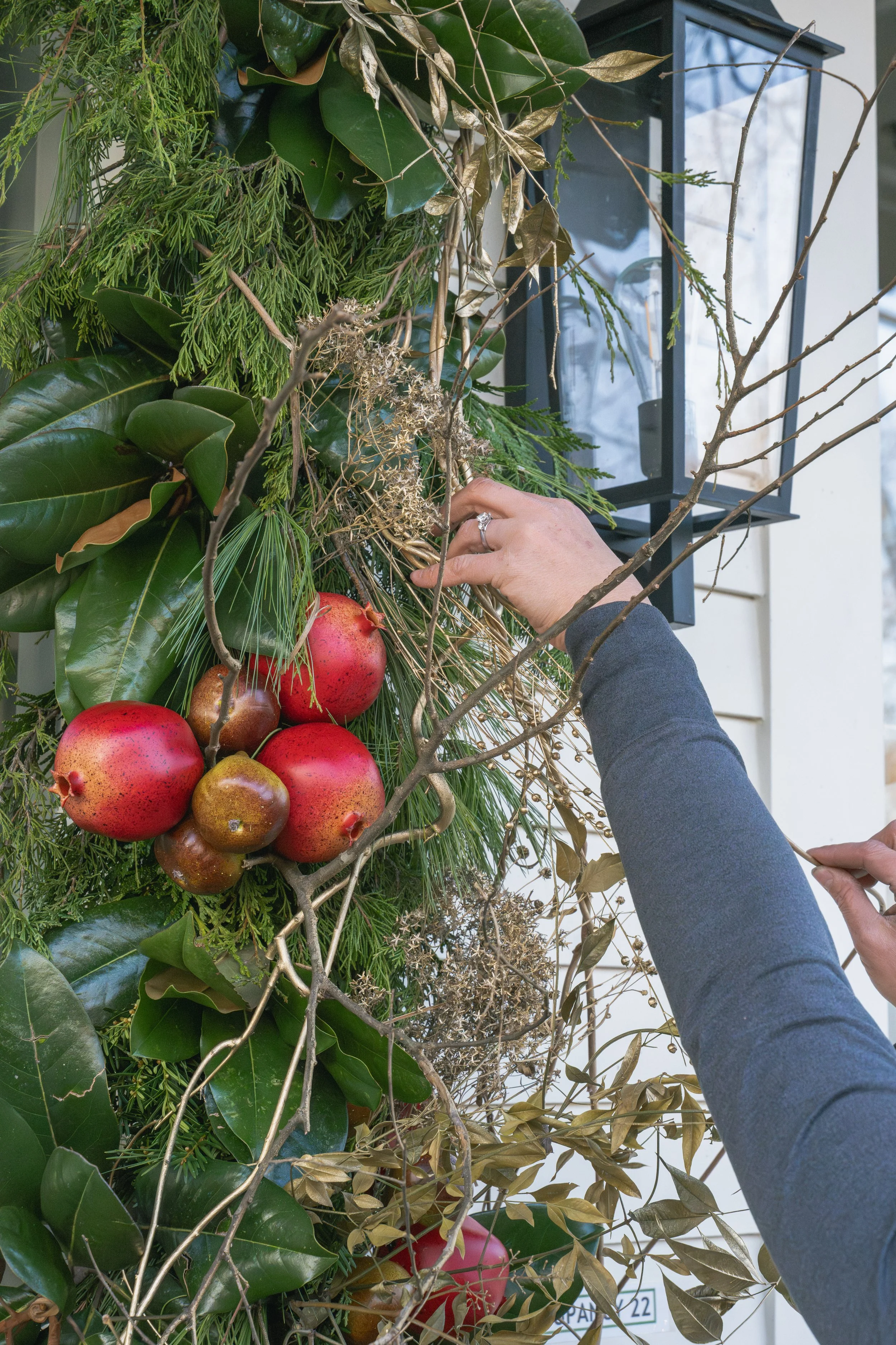 Hands placing branches among magnolia leaves, evergreen folia