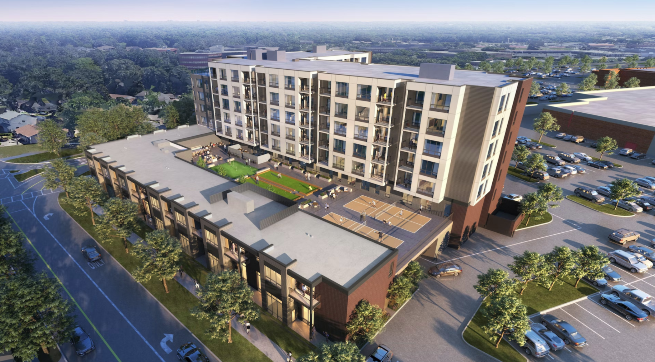 A modern multi-story apartment building with balconies, surrounded by a parking lot filled with cars, trees, and a recreational area with basketball courts and a green space.