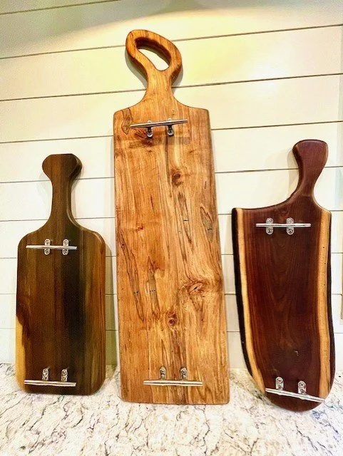 Hand-finished charcuterie / cutting boards now in stock. Includes from left, Rainbow Poplar (25" x 10"), $250; Spalted Maple, (40" x 11"), $375; Black Walnut, (24" x 10"), $250. All finished with FDA-approved butcher block bees wax, oil with stainles