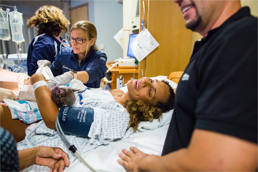 Mama smiles in relief and holds new baby after fast delivery, Philadelphia Hospital Birth Photographer