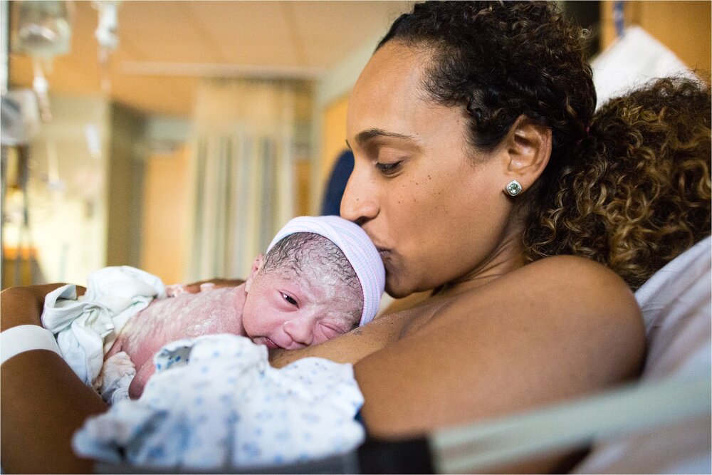 Brand new baby girl gets a kiss on the head from mama after fast hospital birth, Philadelphia Newborn Photographer