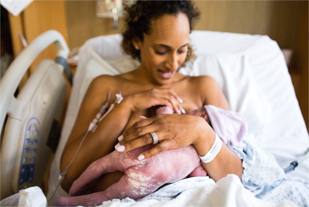 Mama admires her new baby girl after fast hospital delivery, tush covered in vernix, Philadelphia Birth Photographer