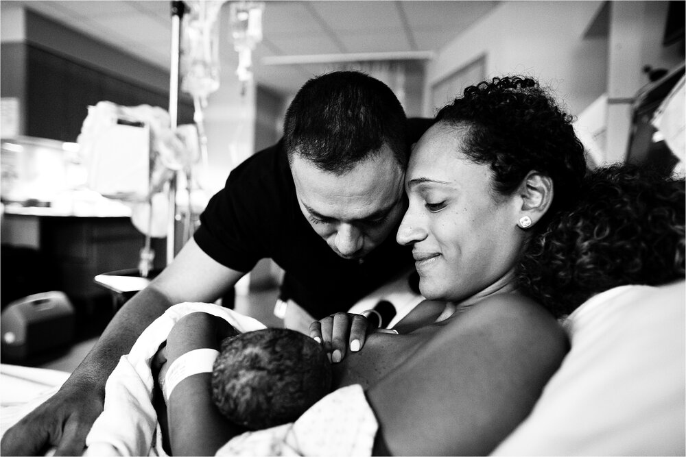 Mom and dad share a quiet moment while new baby girl breastfeeds, Philadelphia Hospital Birth Photographer