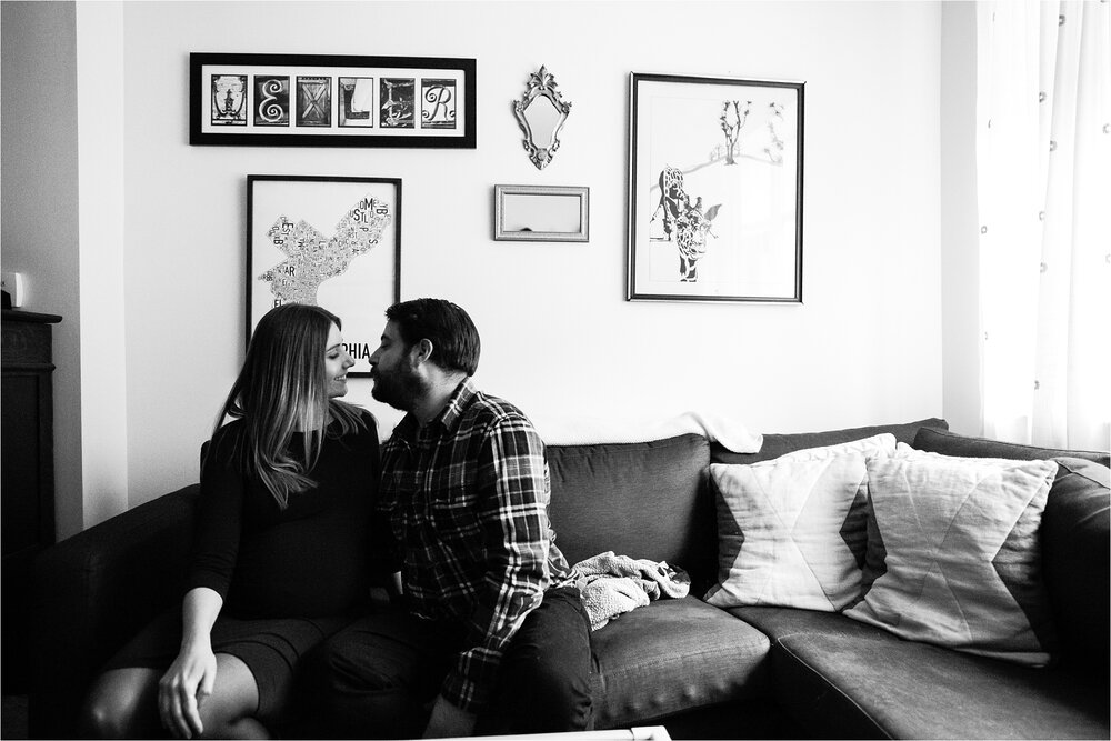 Mom and dad steal a quiet moment to kiss on the couch, Philadelphia Maternity Photographer