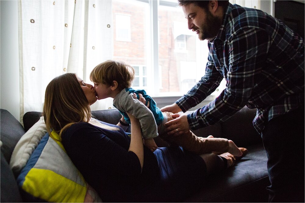 Pregnant mom kisses toddler son as dad brings him over, Philadelphia Maternity Photographer