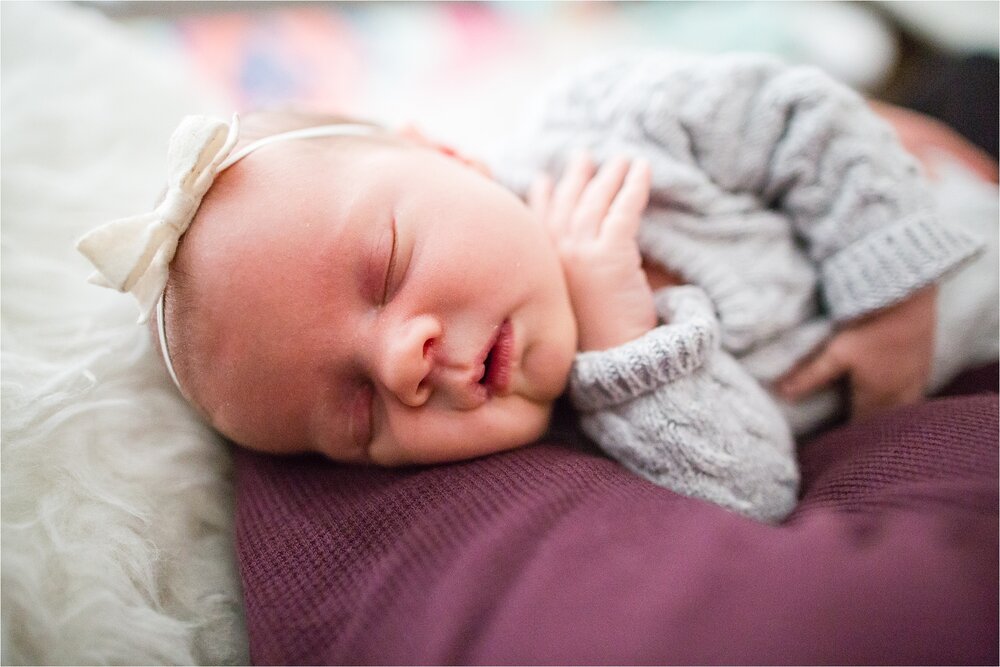 Baby sister sleeps in dads arms with little white bow on her head, Philadelphia Newborn Photographer