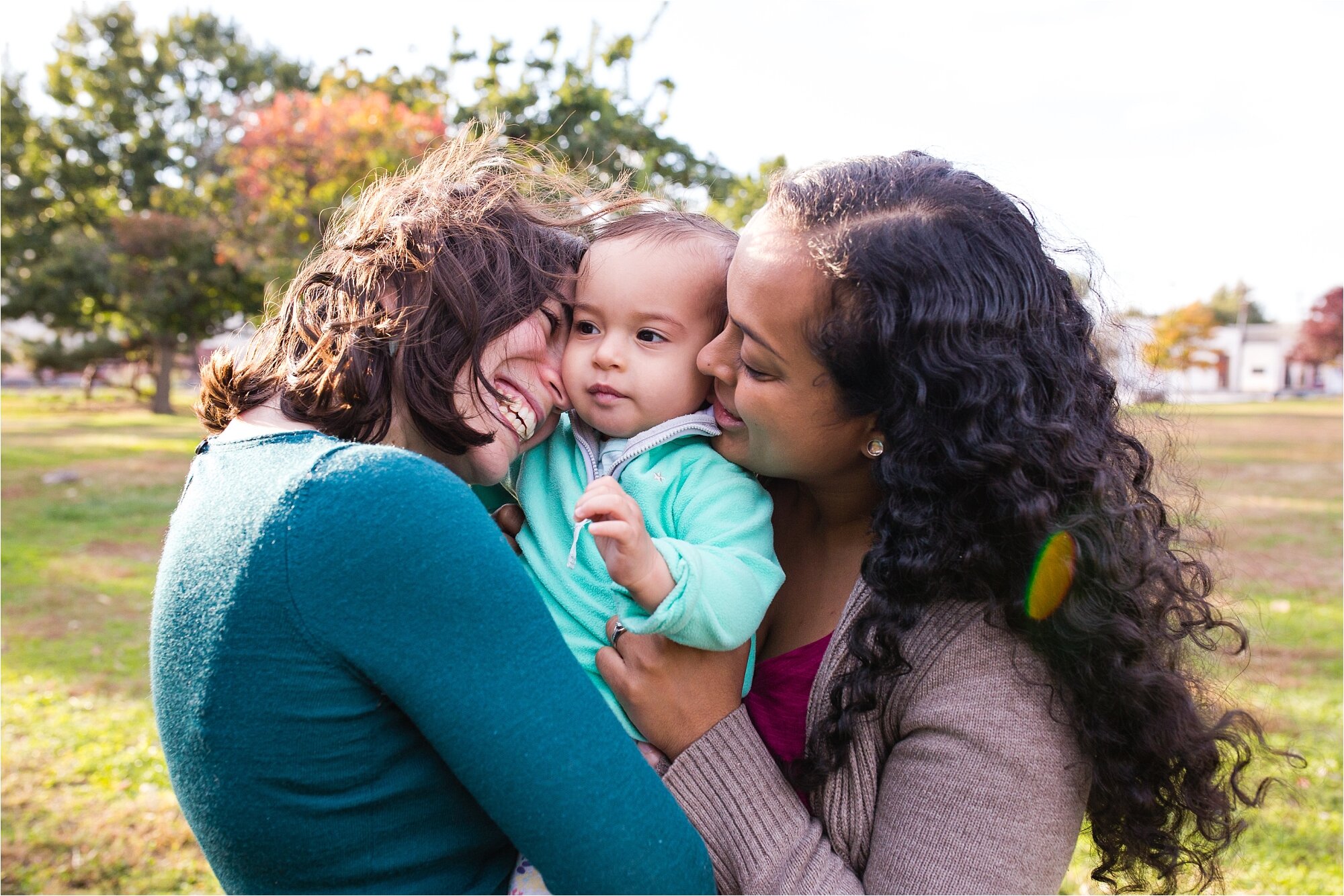 Lesbian gay mommies smile and have a group hug their baby daughter, Family Photographer Philadelphia