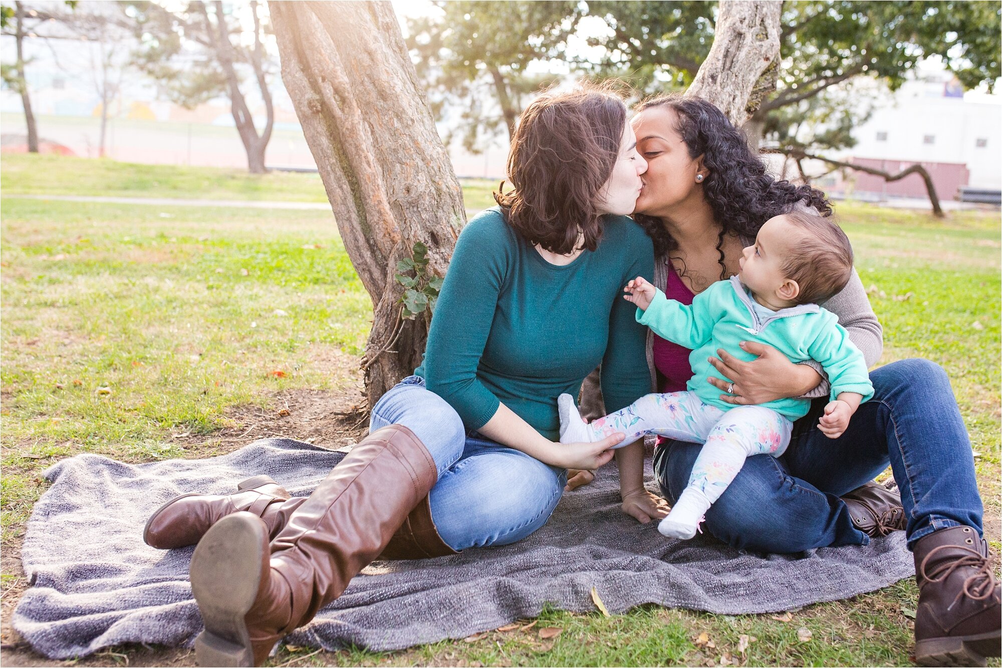 Gay married mommies kiss each other while their daughter looks at them, Family Photograph Philadelphia