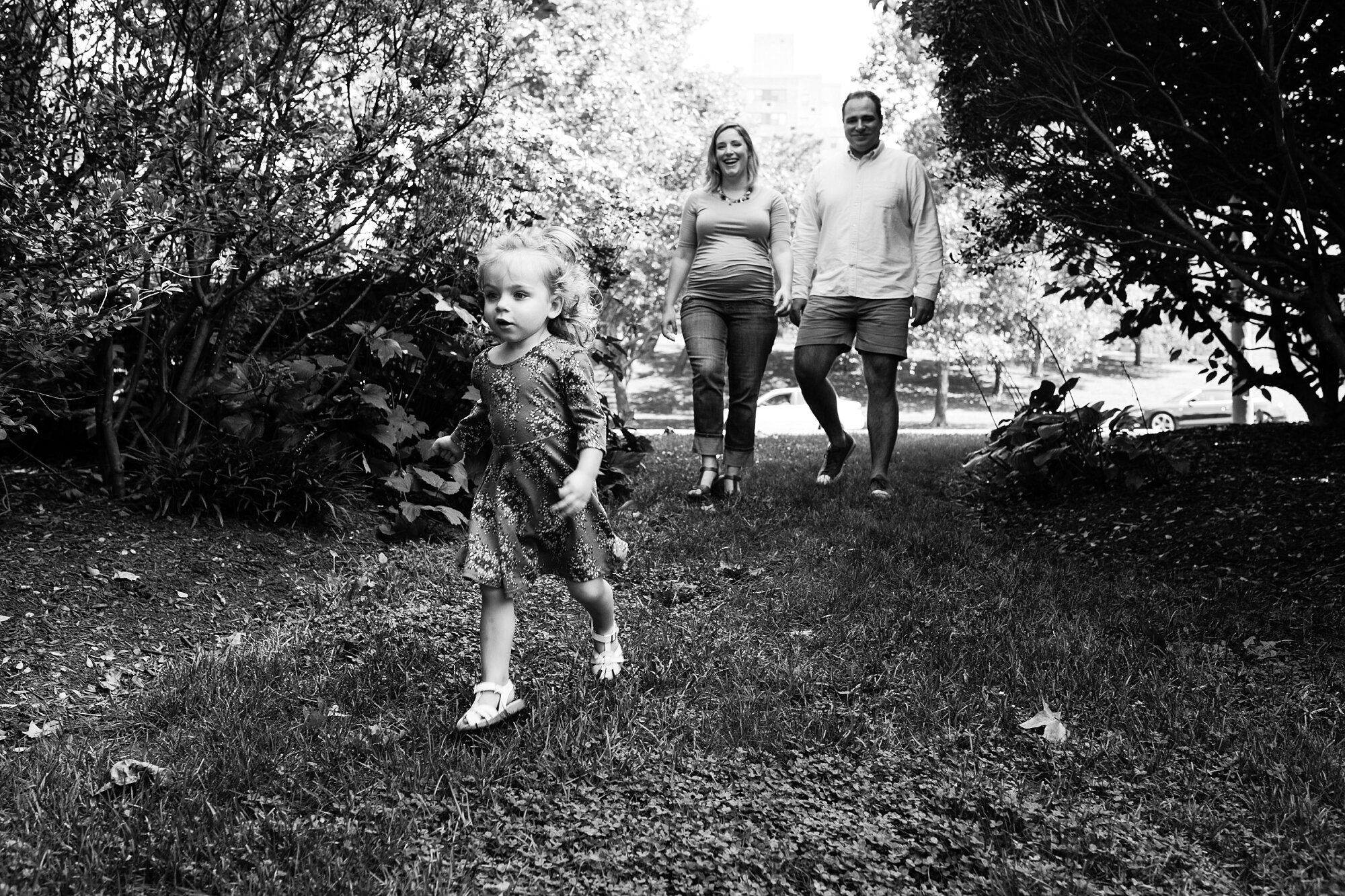 Family of three laughs and walks through the Azalea Gardens, Fairmount, Philadelphia Family Photographer