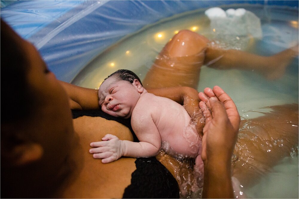 Minutes old baby skin to skin with mom after being born in the water, home birth, home water birth Photographer Philadelphia