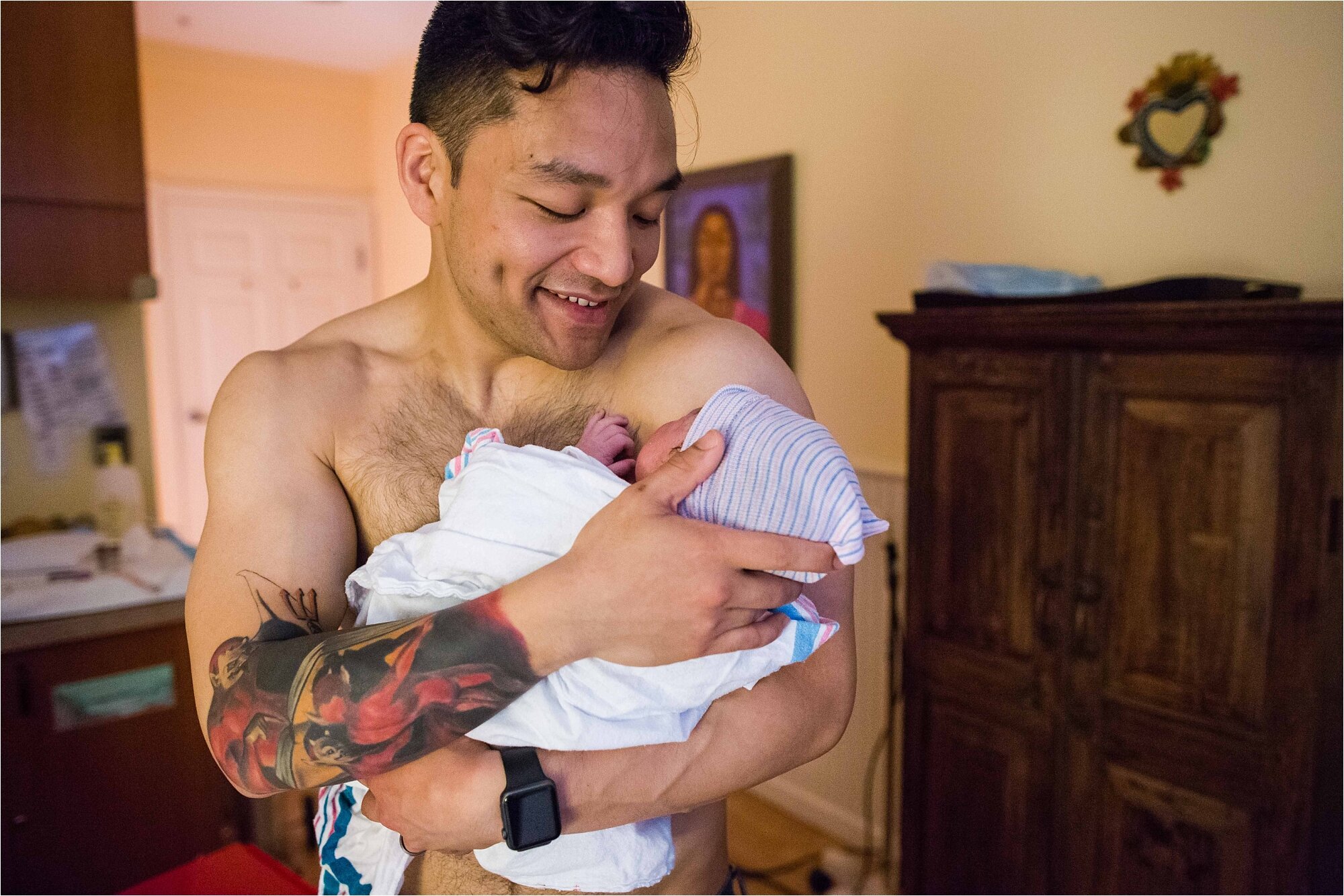 Dad holds brand new son skin to skin after just being born, Philadelphia birth center photographer