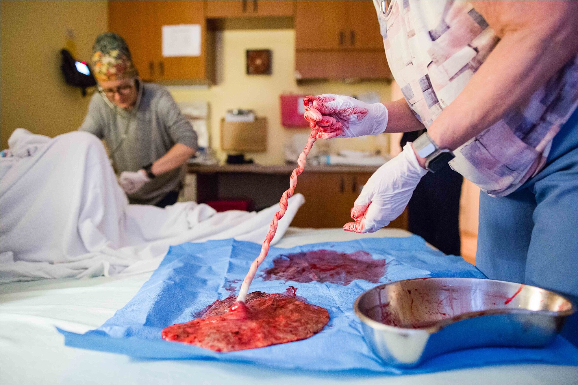 Midwife examines placenta and cord after mom delivers, Philadelphia birth center photography
