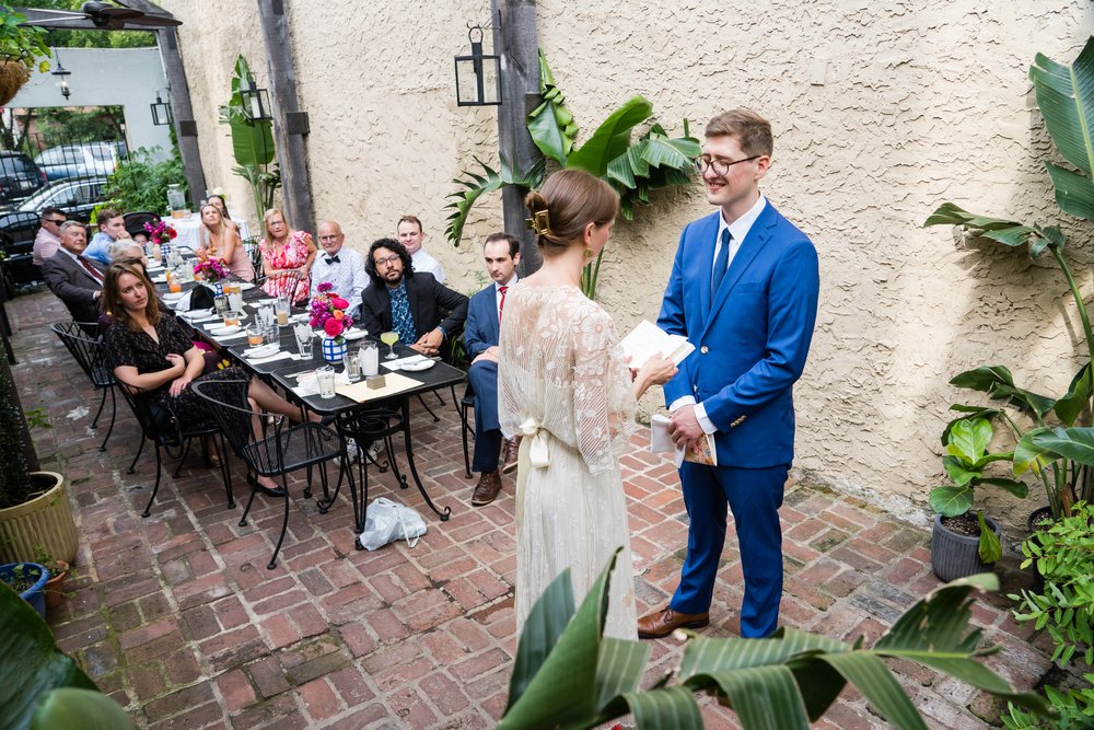 Overhead view of bride and groom exchanging vows, guests watching in background, Philadelphia wedding photographer