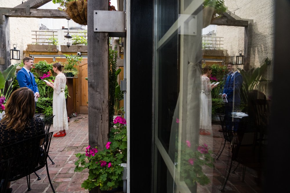 Creative portrait of bride and groom exchanging vows and reflected in windows, Philadelphia wedding photography