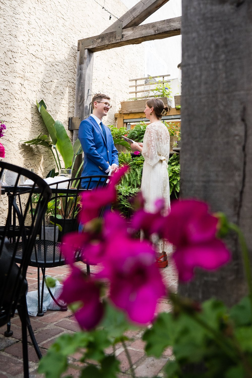 Bride and groom exchanging vows seen through bright flowers, Philadelphia wedding photography