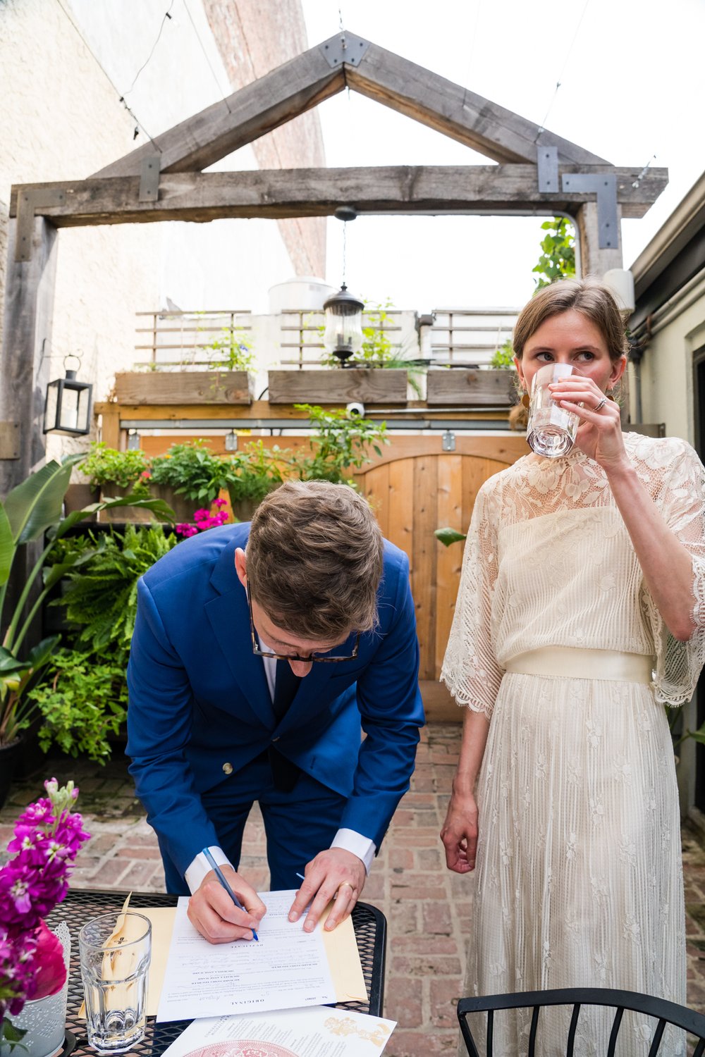 Bride takes a drink as groom signs wedding license, Philadelphia wedding documentary