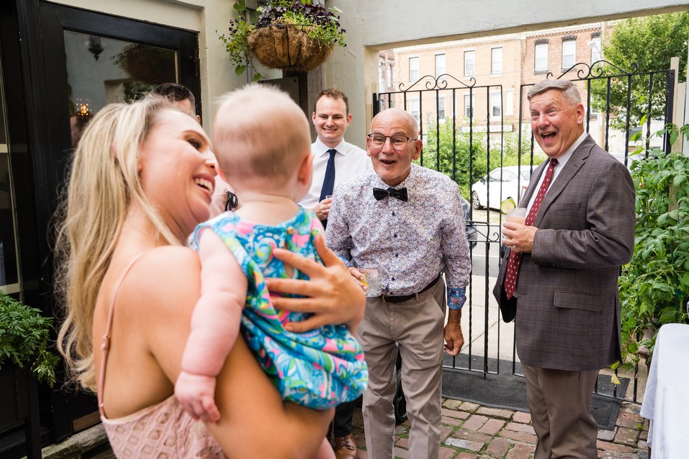 Wedding guests make silly faces to entertain baby, Philadelphia photographer