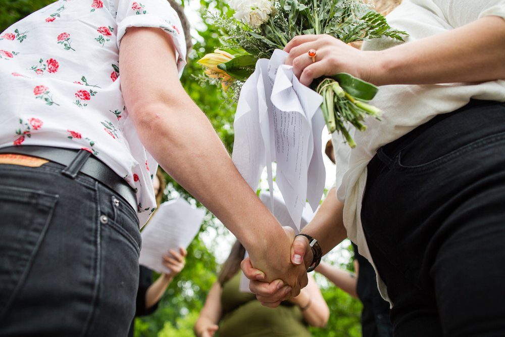 Detail shot of couple holding hands, rings, wedding reading, flowers, Philadelphia photographer