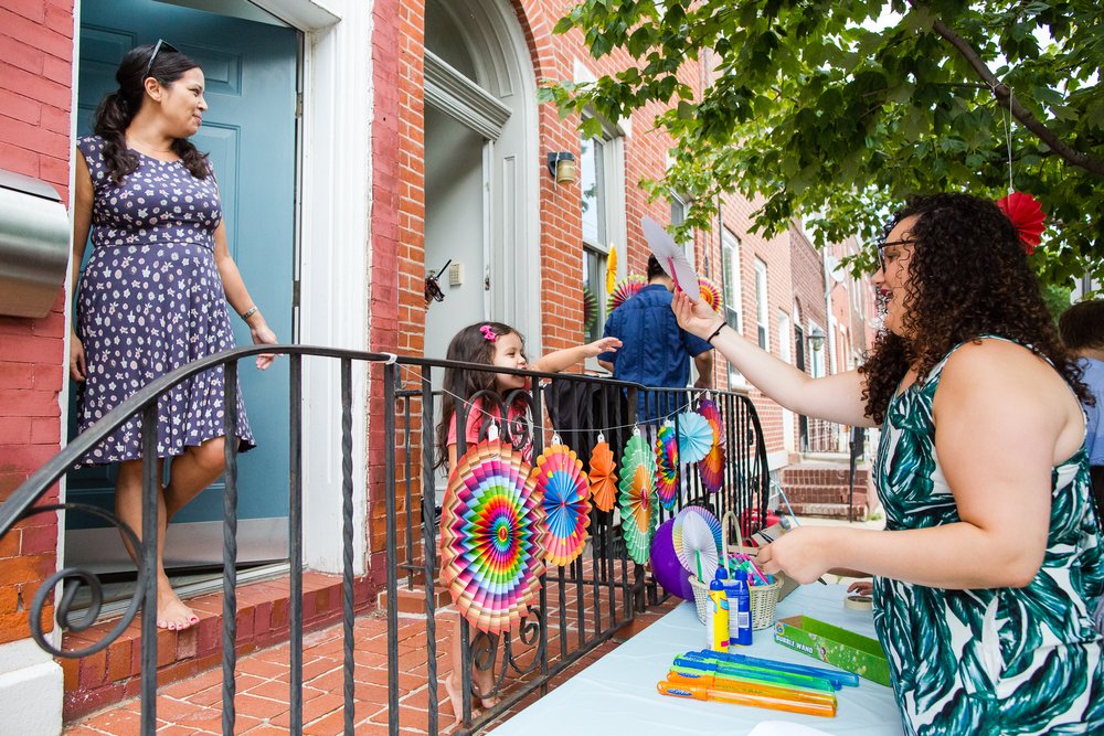 Neighbors get ready for block party wedding, cute kid gets a wedding favor, Philadelphia documentary photographer