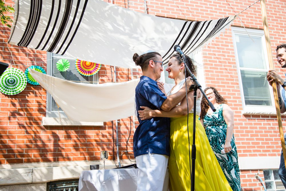 Bride and groom embrace and smile at each other under chuppah, beautiful dappled light, Philadelphia wedding photographer