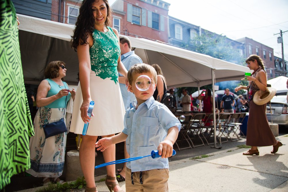 Cute kid blows bubbles at block party reception, Philadelphia wedding photography