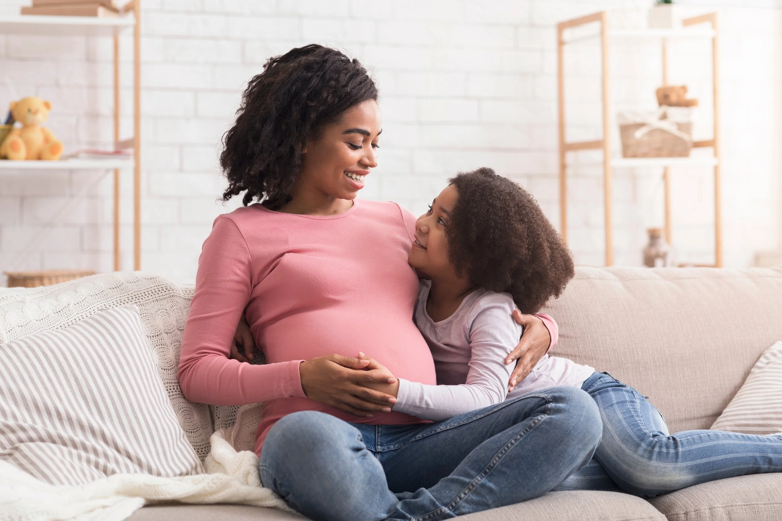 Pregnant mother spending time with her school-age child as they prepare to welcome a new baby